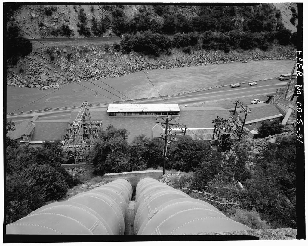 A black and white image shows two pipes descending into a valley.