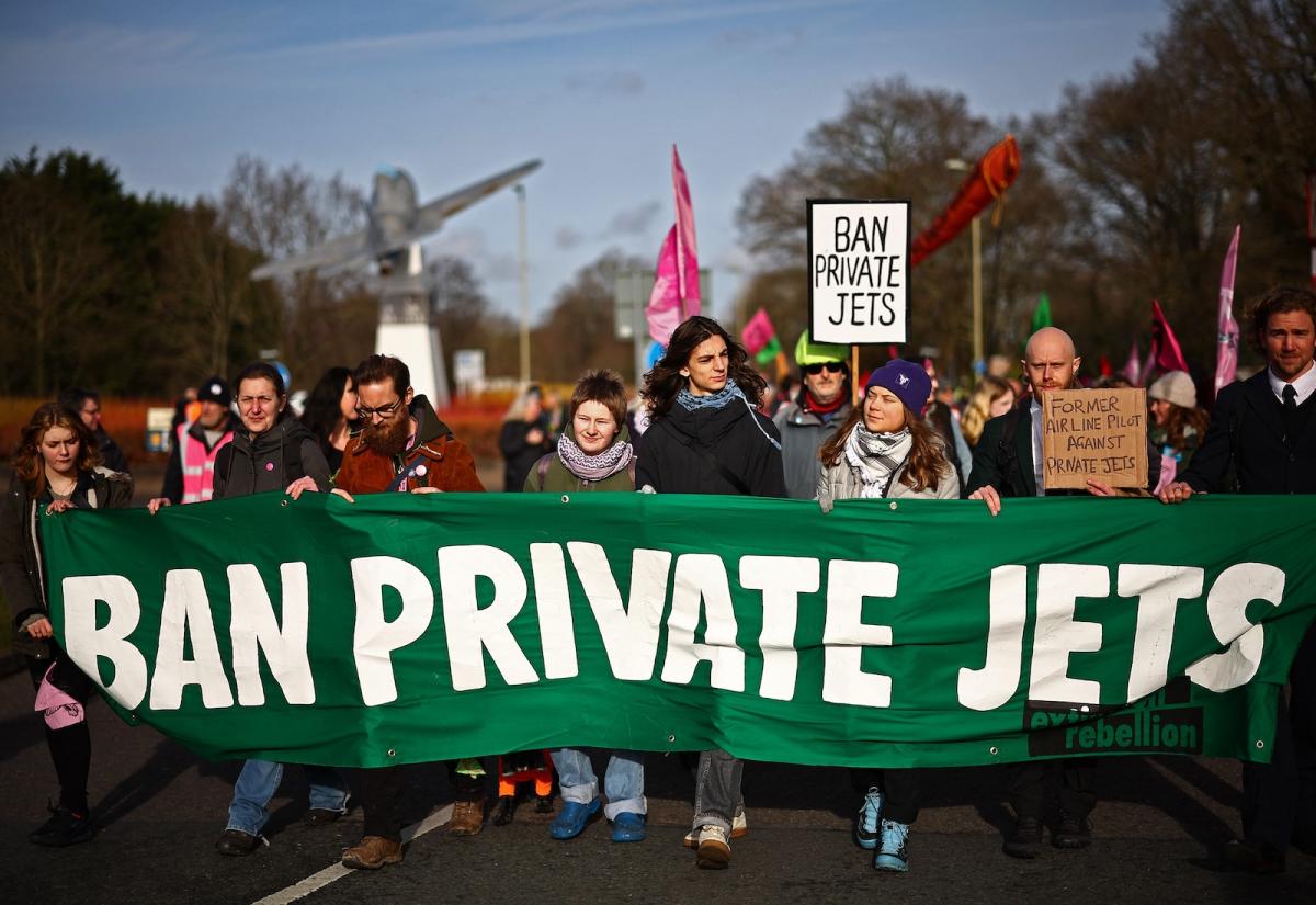 A sign held by protesters reading "ban private jets"