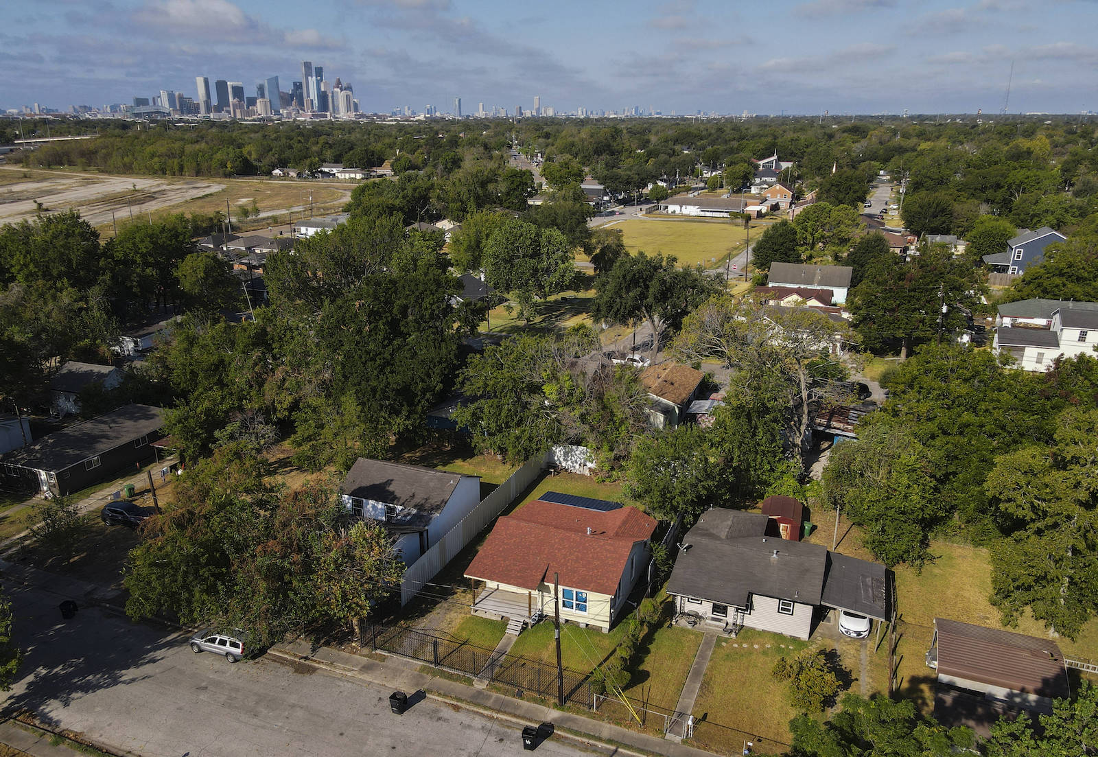 An aerial view of houses with downtown Houston in the distance