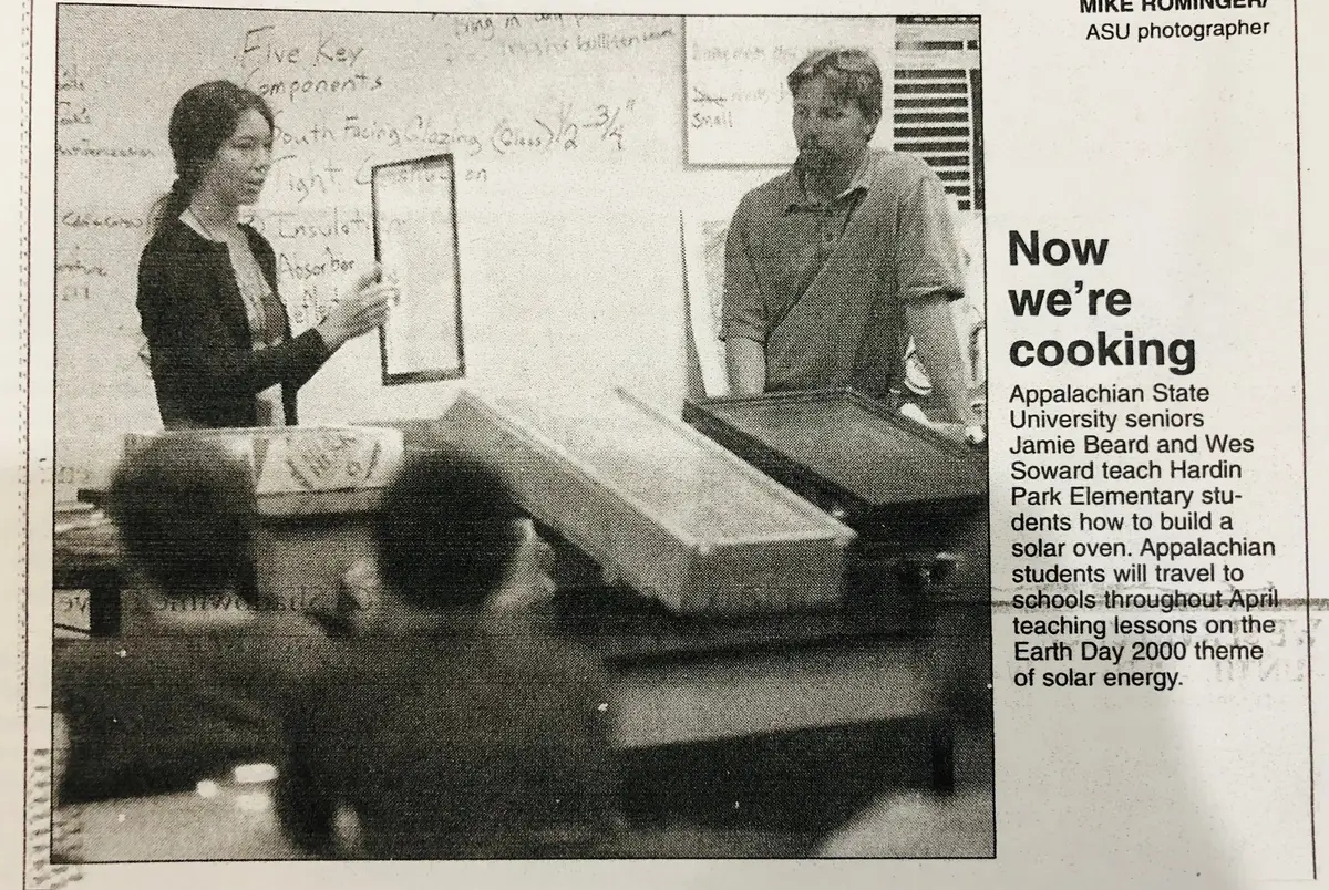 A black and white newspaper clipping shows a woman and a man at the front of a classroom.