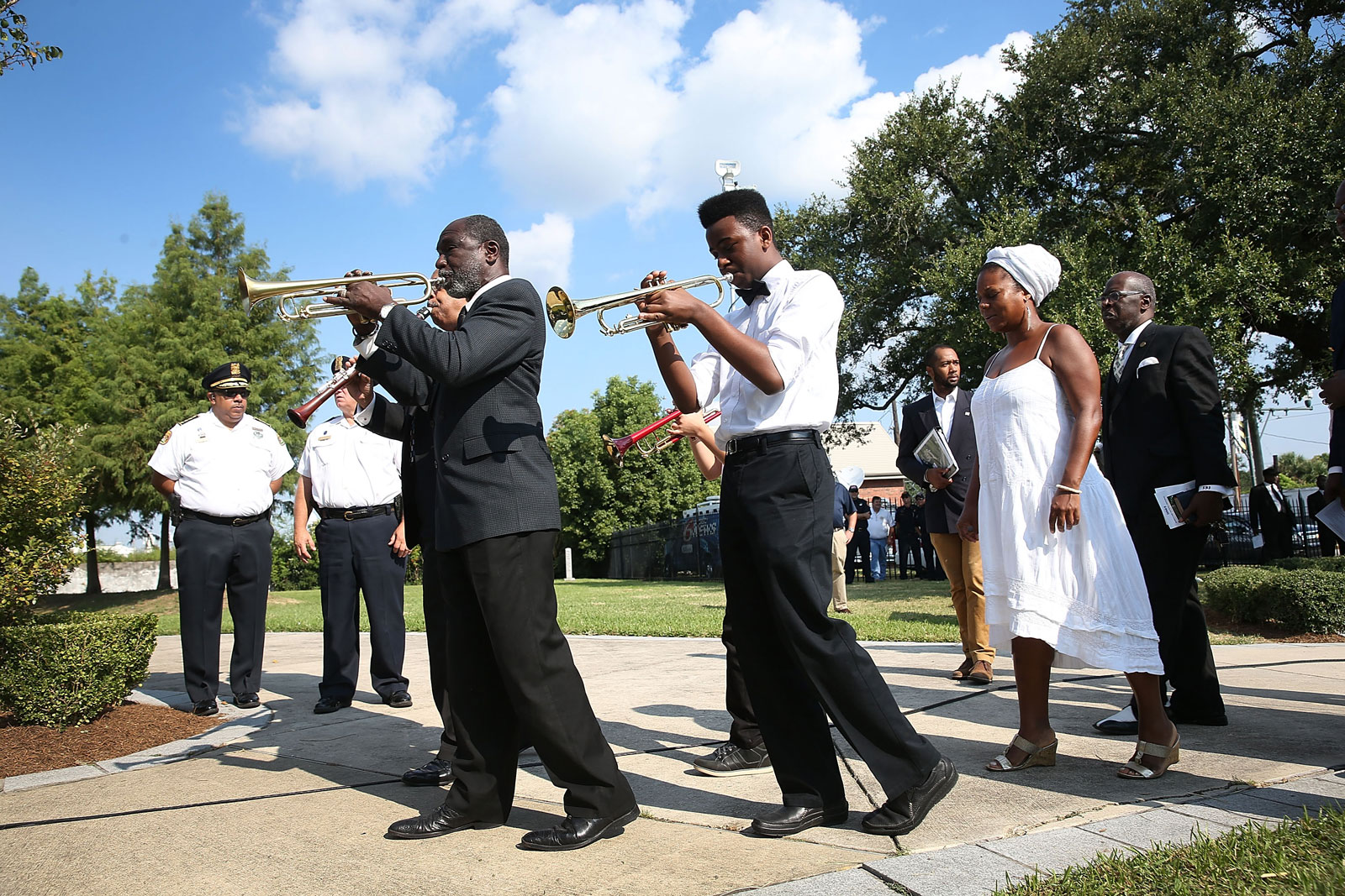 Members of a jazz funeral procession playing trumpets
