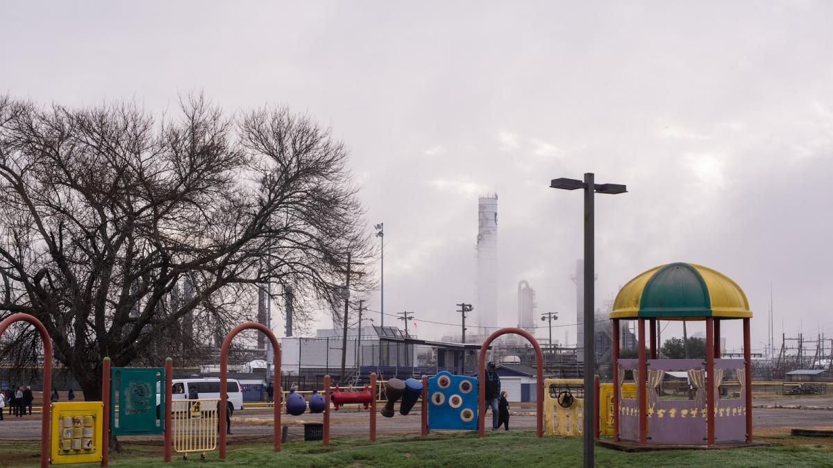 Playground in foreground with petrochemical plant in background
