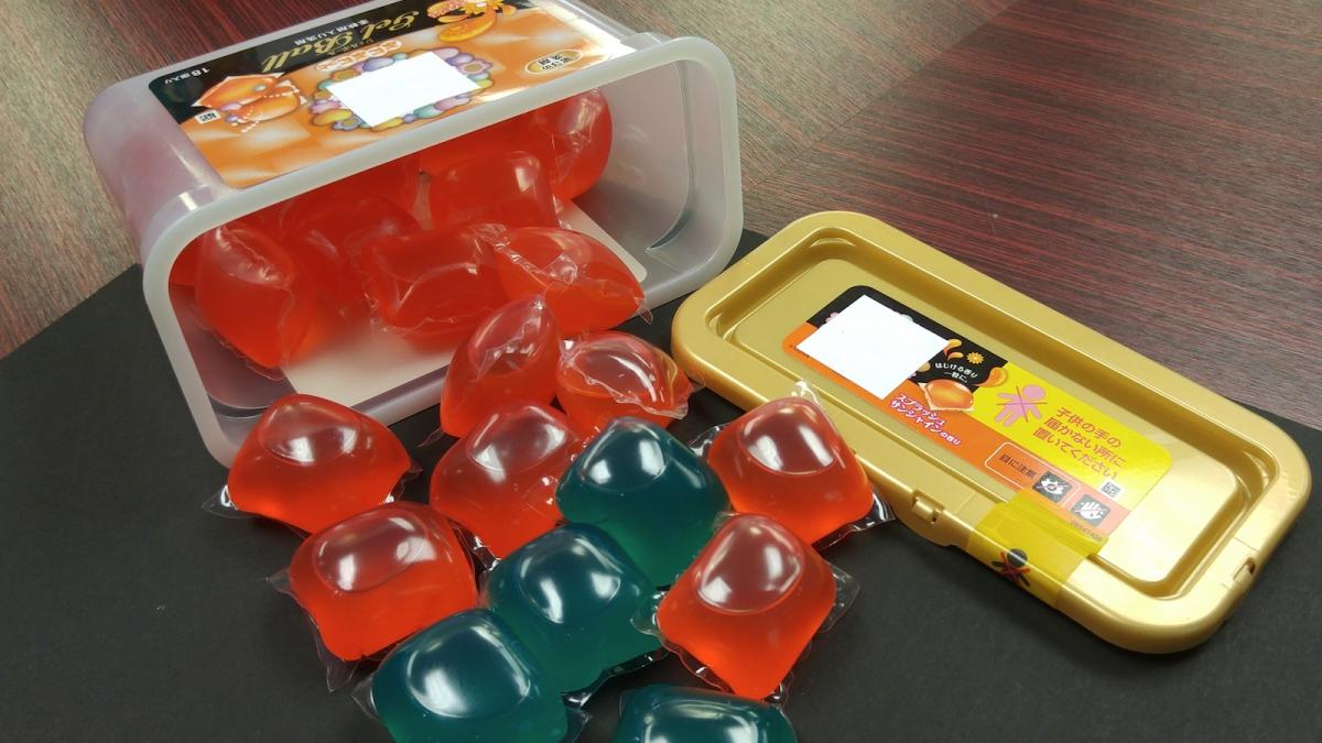 Laundry detergent pods spilling from a container.