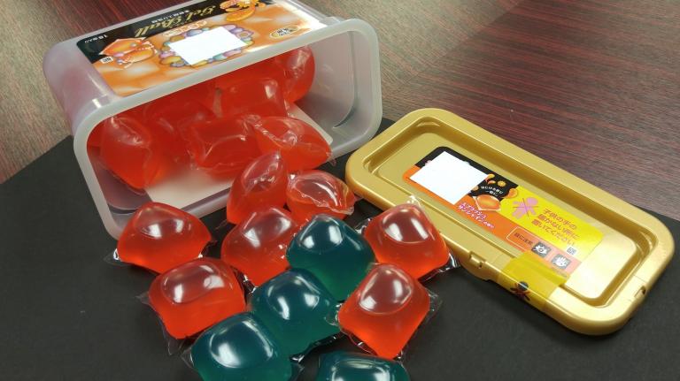 Laundry detergent pods spilling from a container.
