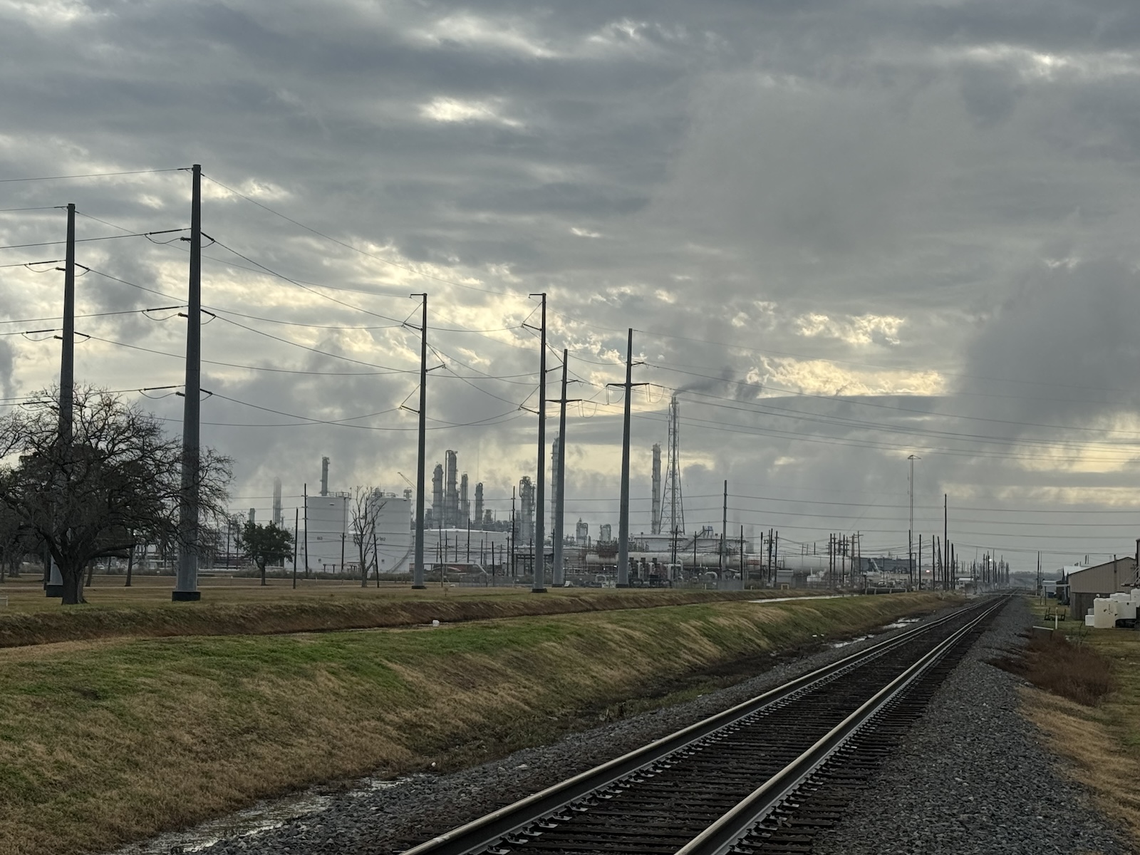 Railroad tracks with petrochemical plant in background