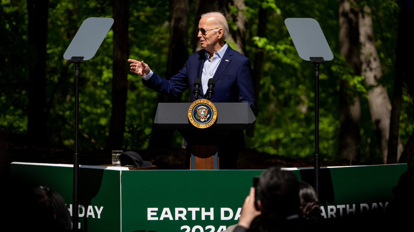 Biden wears sunglasses at a podium marked Earth Day 2024