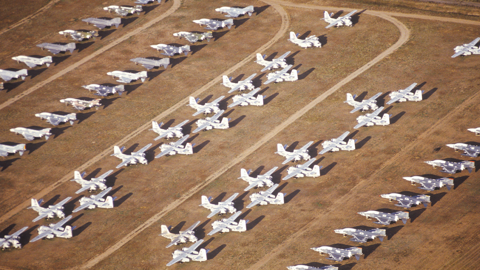diagonally framed rows of white airplanes from an aerial view