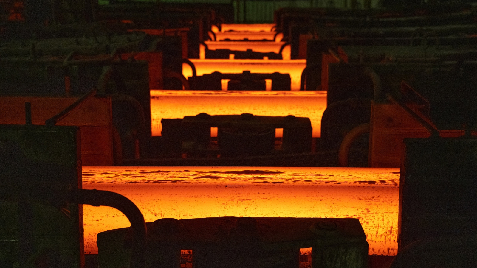 Lengths of red hot steel in a factory.