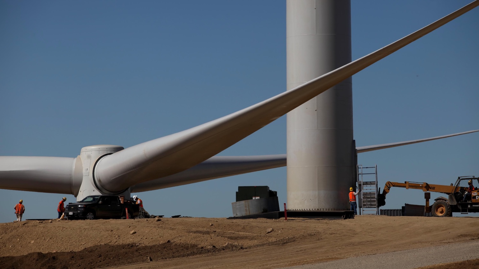 Crews on a ridgeline prepare to install a huge rotor on a wind turbine on Altamont Pass in the San Francisco Bay Area.