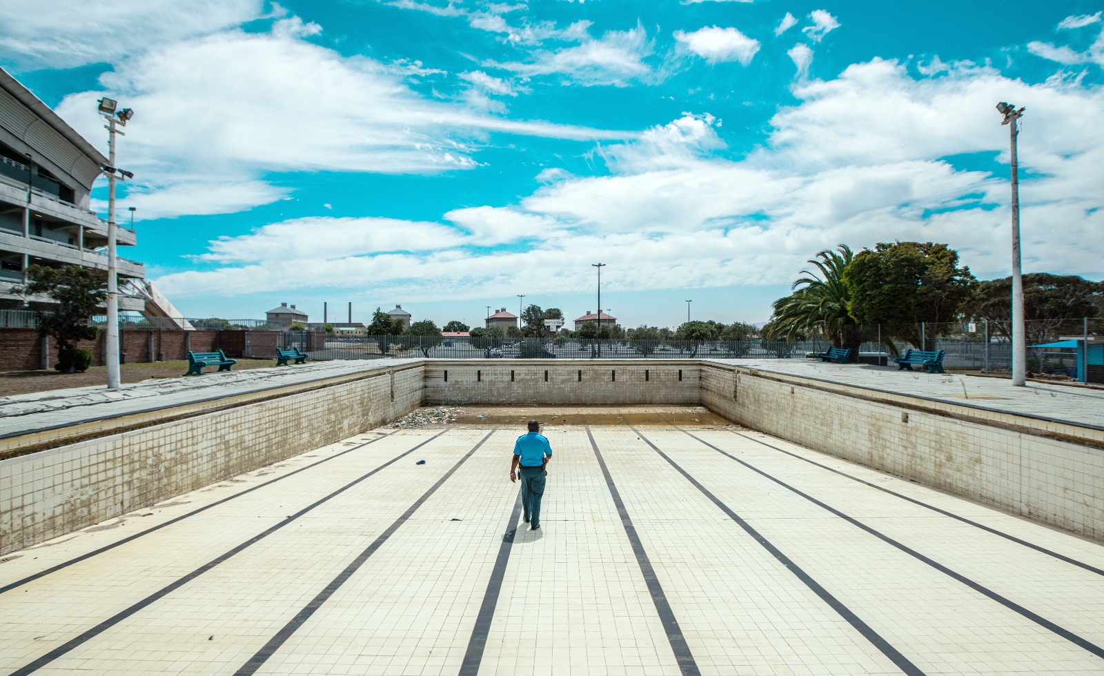 Un policier inspecte une piscine publique vide au Cap, en Afrique du Sud.  Le gouvernement de la ville a réussi à surmonter une crise de sécheresse en 2018 en réduisant la consommation d'eau domestique à un niveau sans précédent.