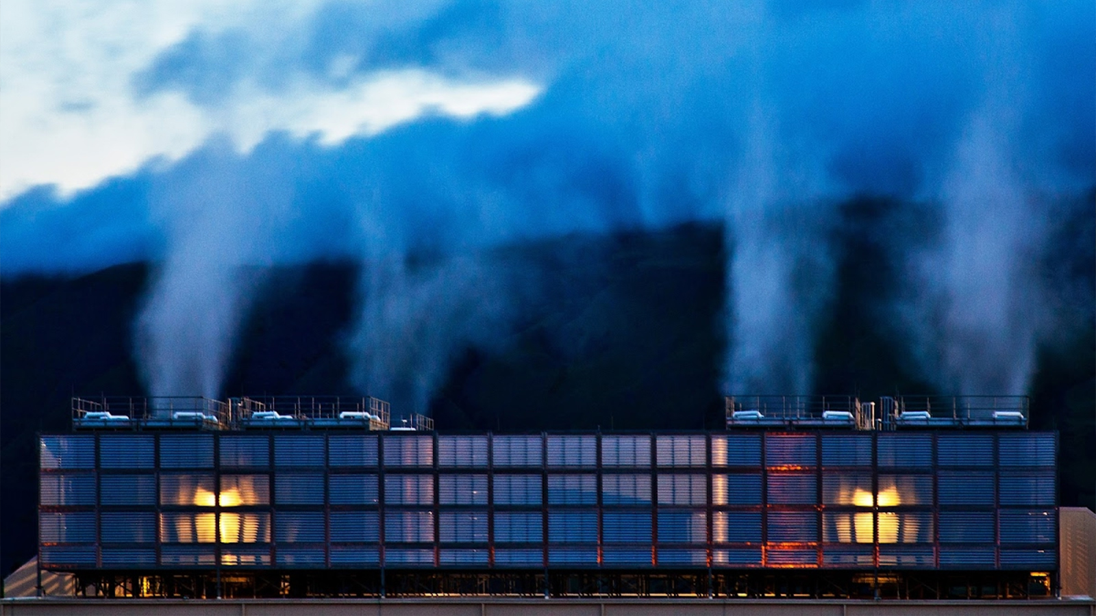 Steam rises above the cooling towers in The Dalles data center in Oregon. These plumes of water vapor create a quiet mist at dusk.