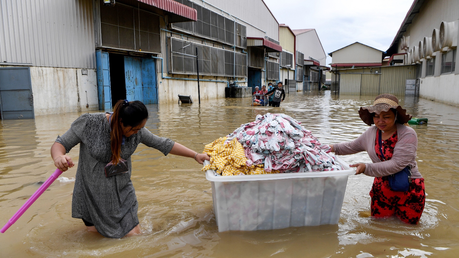 Textile workers wade through floodwaters in Cambodia.