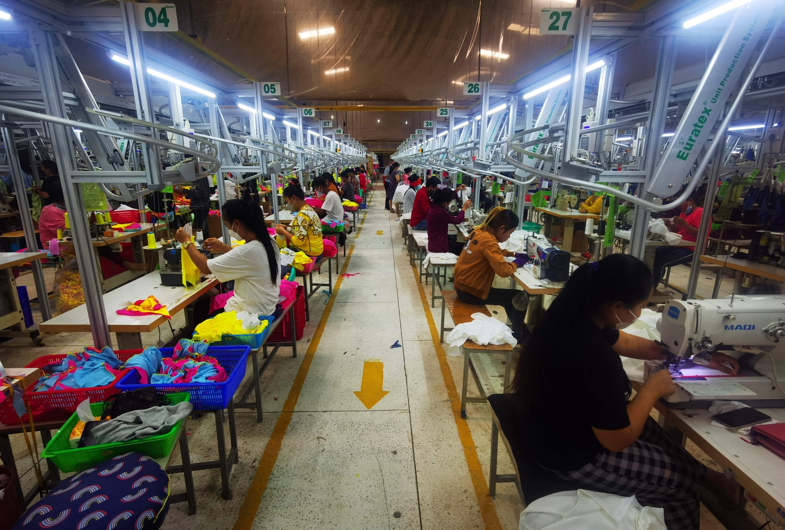 Employees sit at sewing machines at a garment factory in Cambodia