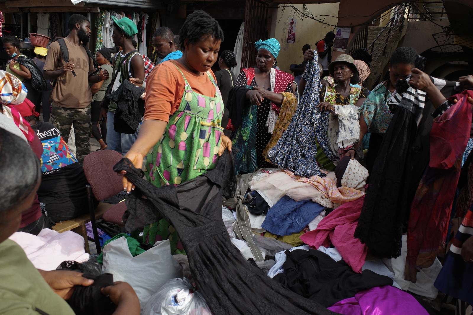 Women sort through secondhand clothes at a market in Ghana