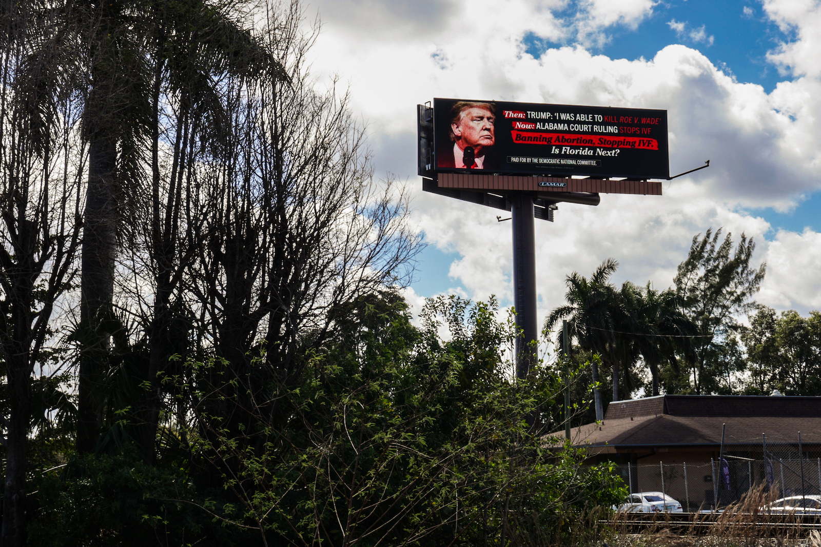 A billboard with a photo of Trump that hints that Trump policies will disrupt IVF access in Florida