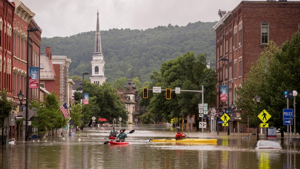 People in kayaks navigate the flooded streets of downtown Montpelier, Vermont in the days after heavy rains during the month of July, 2023, caused extensive flooding throughout the state.