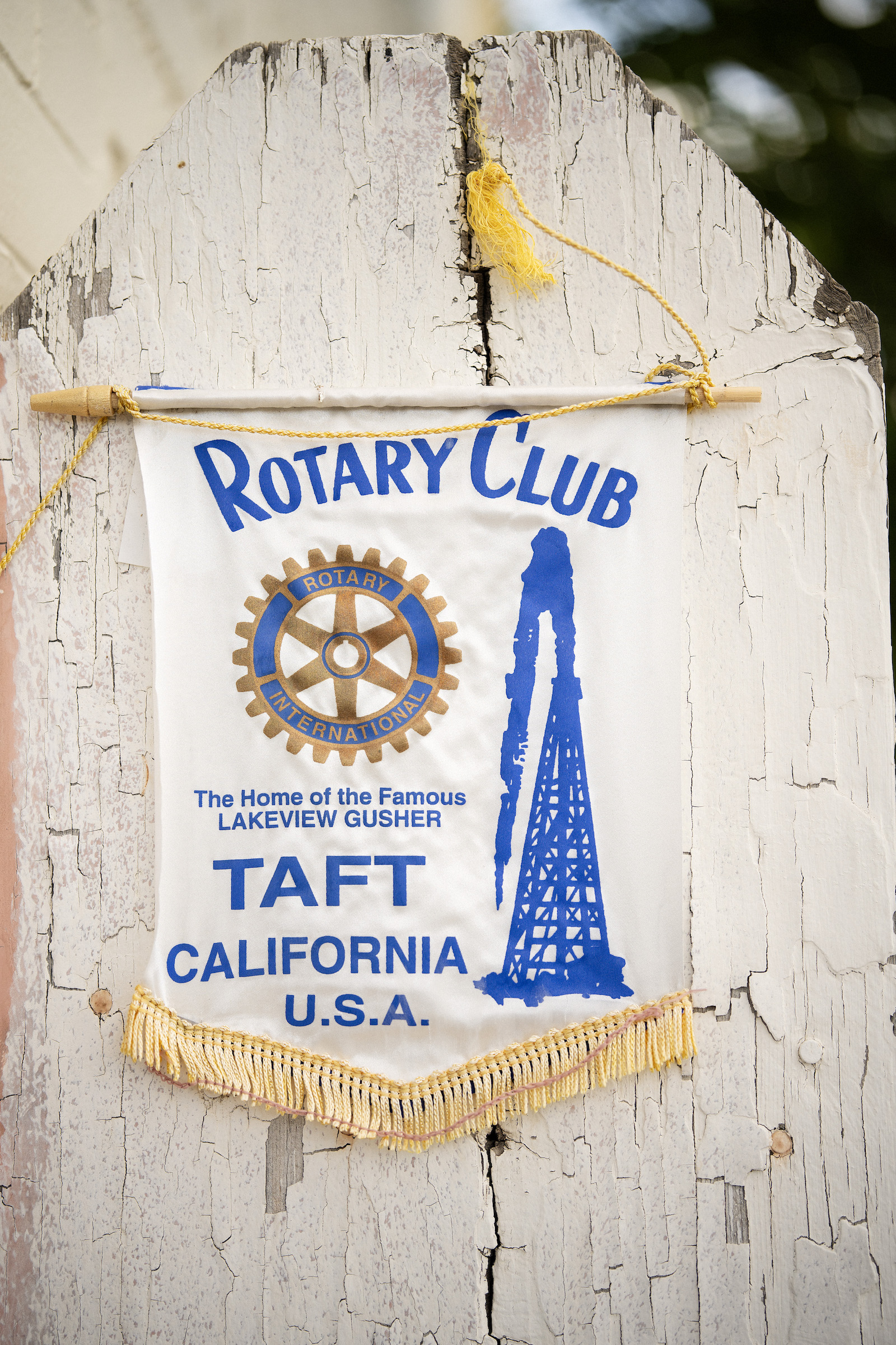 A flag for the rotary club of Taft with an oil tower on it