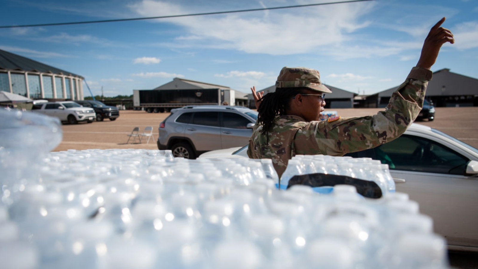 A Mississippi National Guard member directs traffic at a water distribution site at the Mississippi State Fairgrounds in Jackson, Mississippi on September, 1, 2022.
