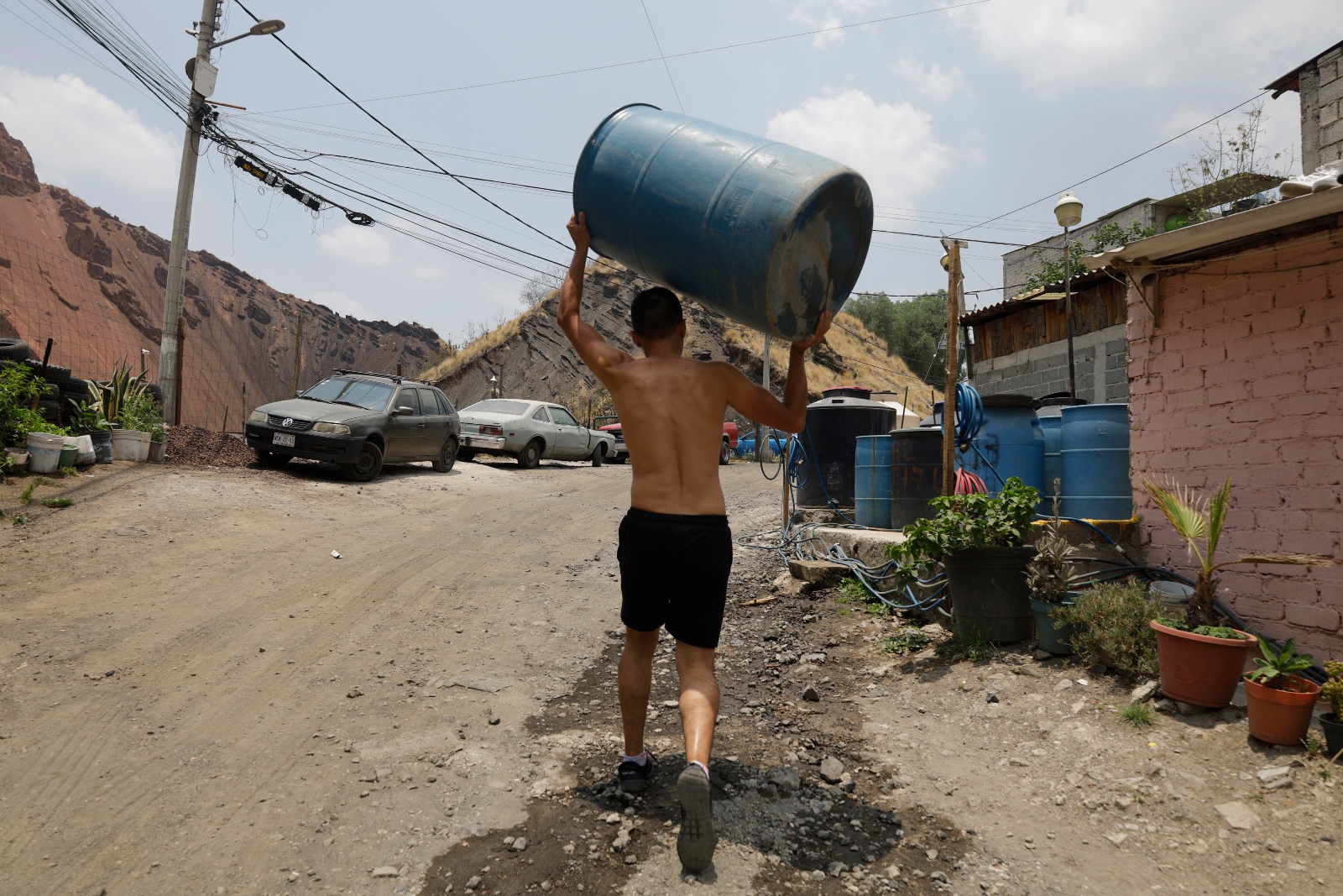 A man carries a barrel for water in the Iztapalapa borough of Mexico City. The city has experienced a worsening water crisis for decades as underground aquifers run dry.