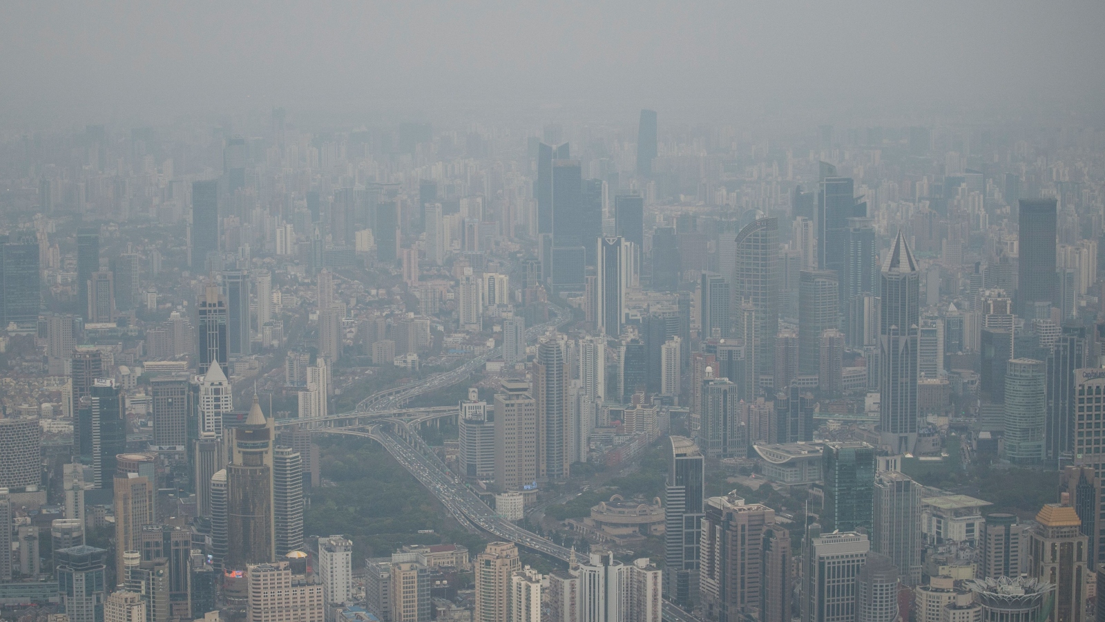 A dense cityscape is filled with smog.