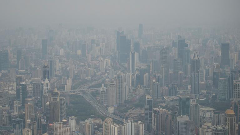 A dense cityscape is filled with smog.