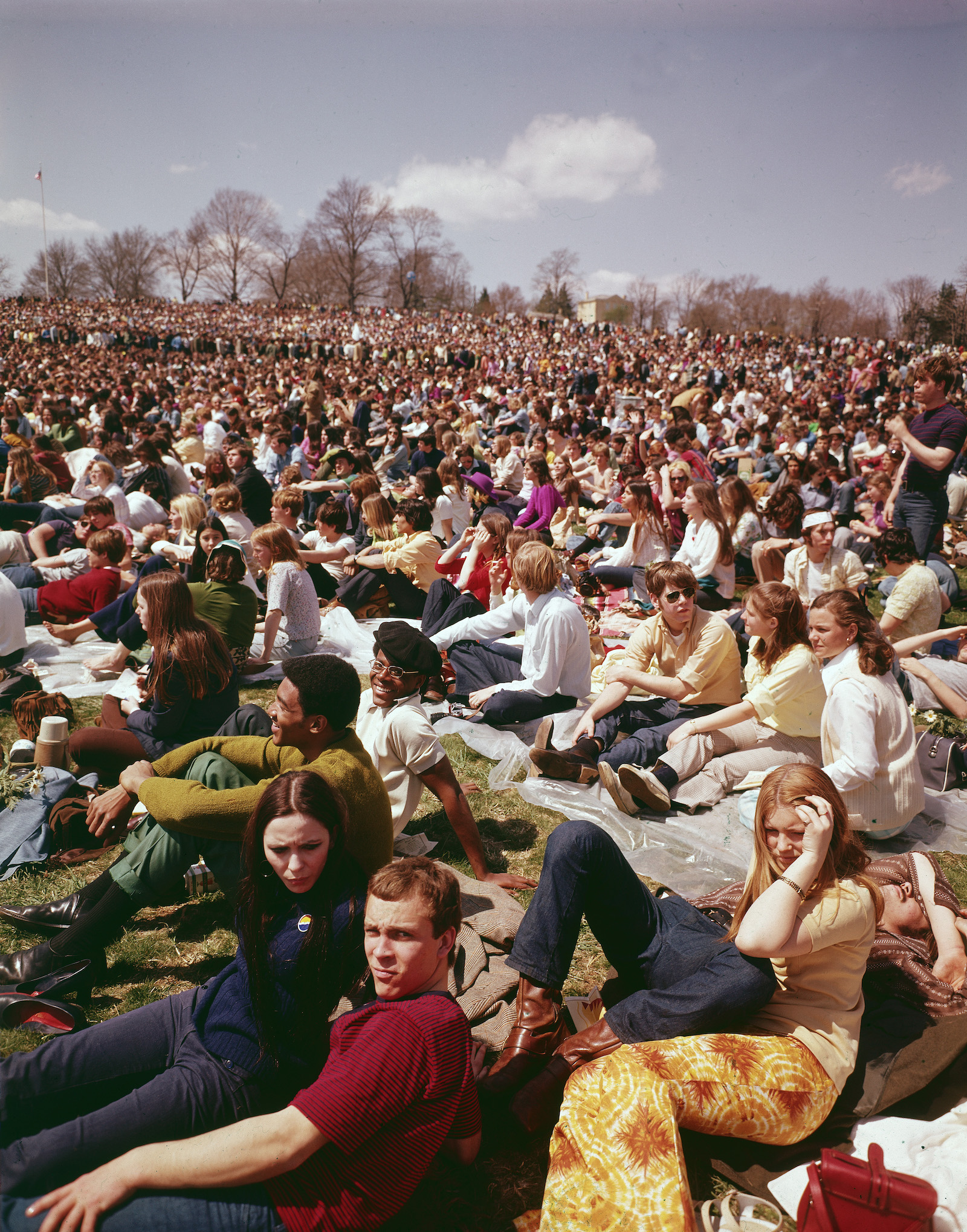 A historic photo of many people sitting on a large lawn