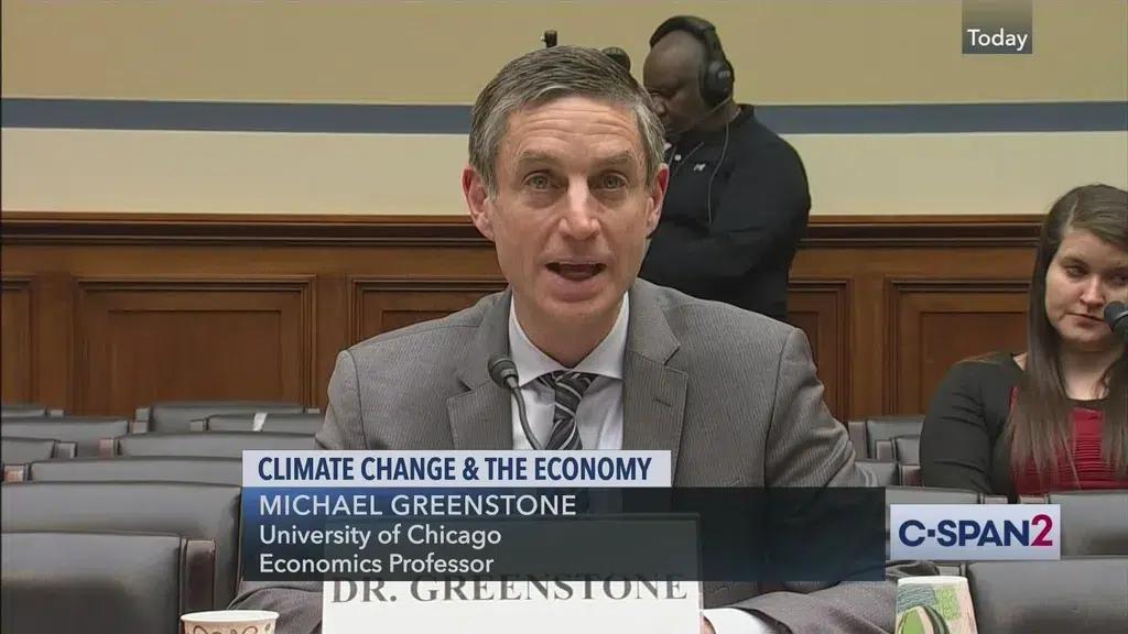 A man with graying hair in a gray suit testifies before Congress.