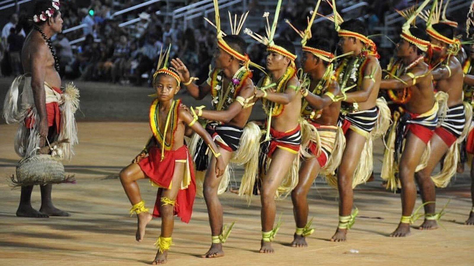 Pacific Islanders in traditional outfits performing at an arts festival