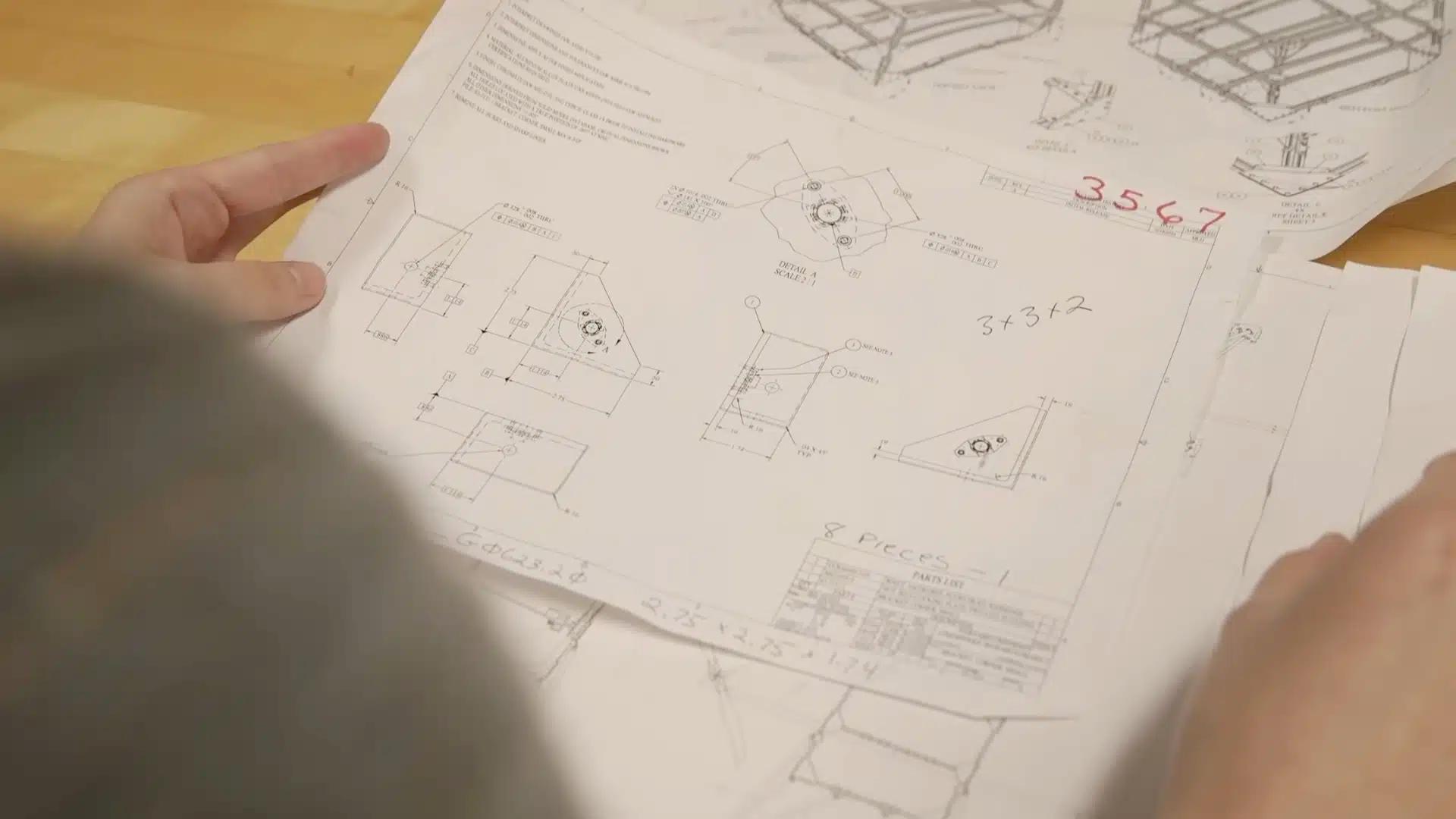 A view of a person holding blueprints.