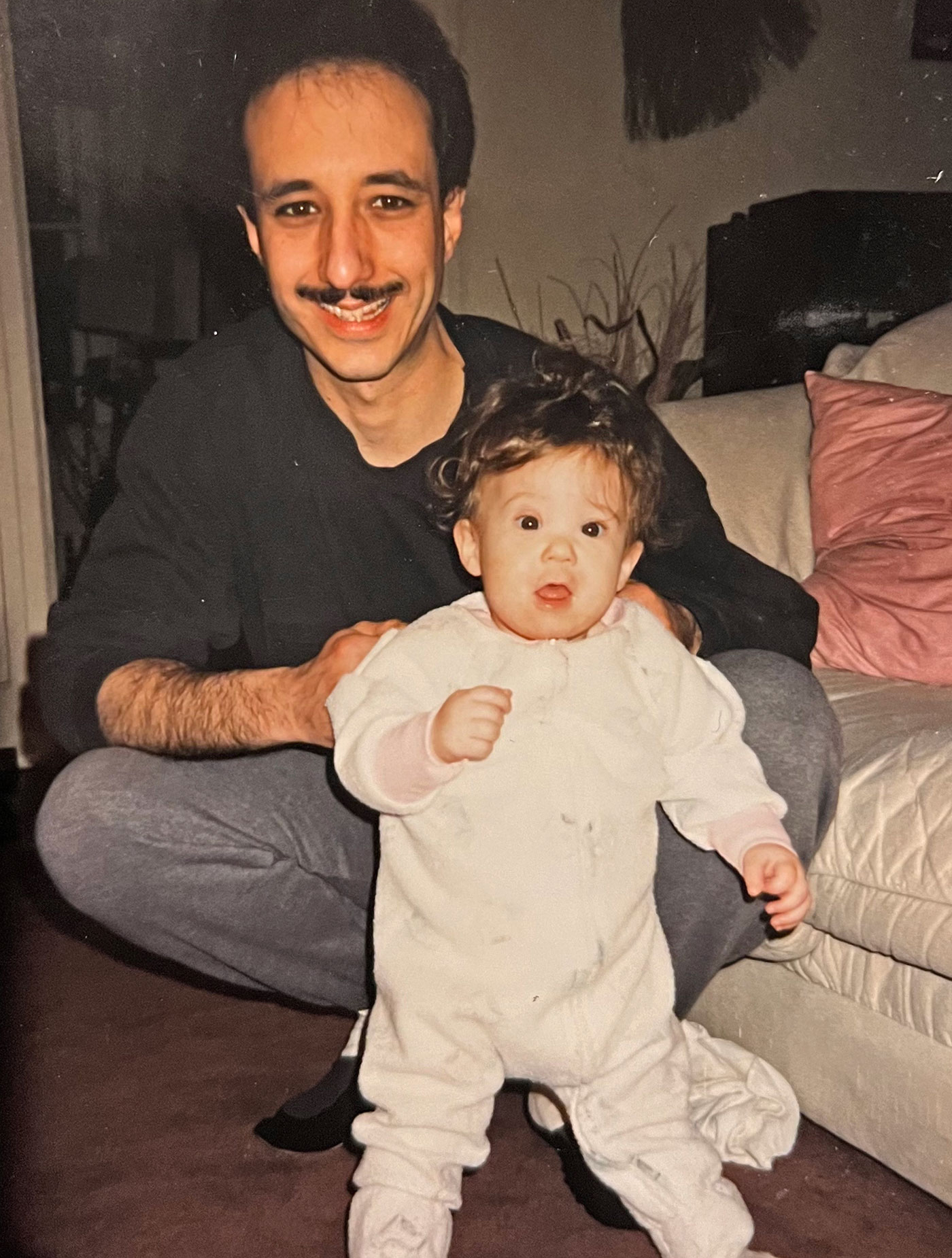 A man with a baby in a onesie