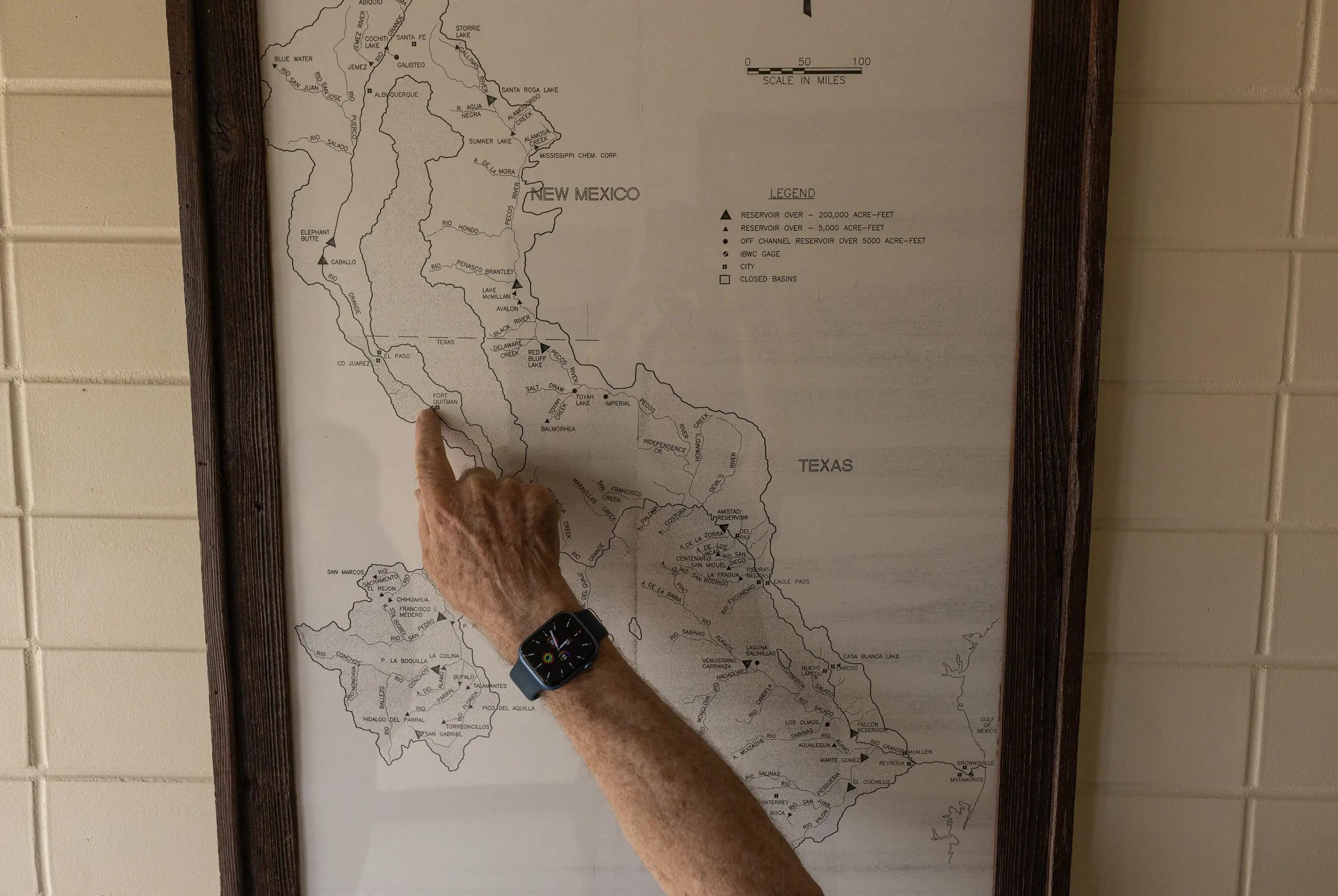 A person's arm points out a spot on a map.