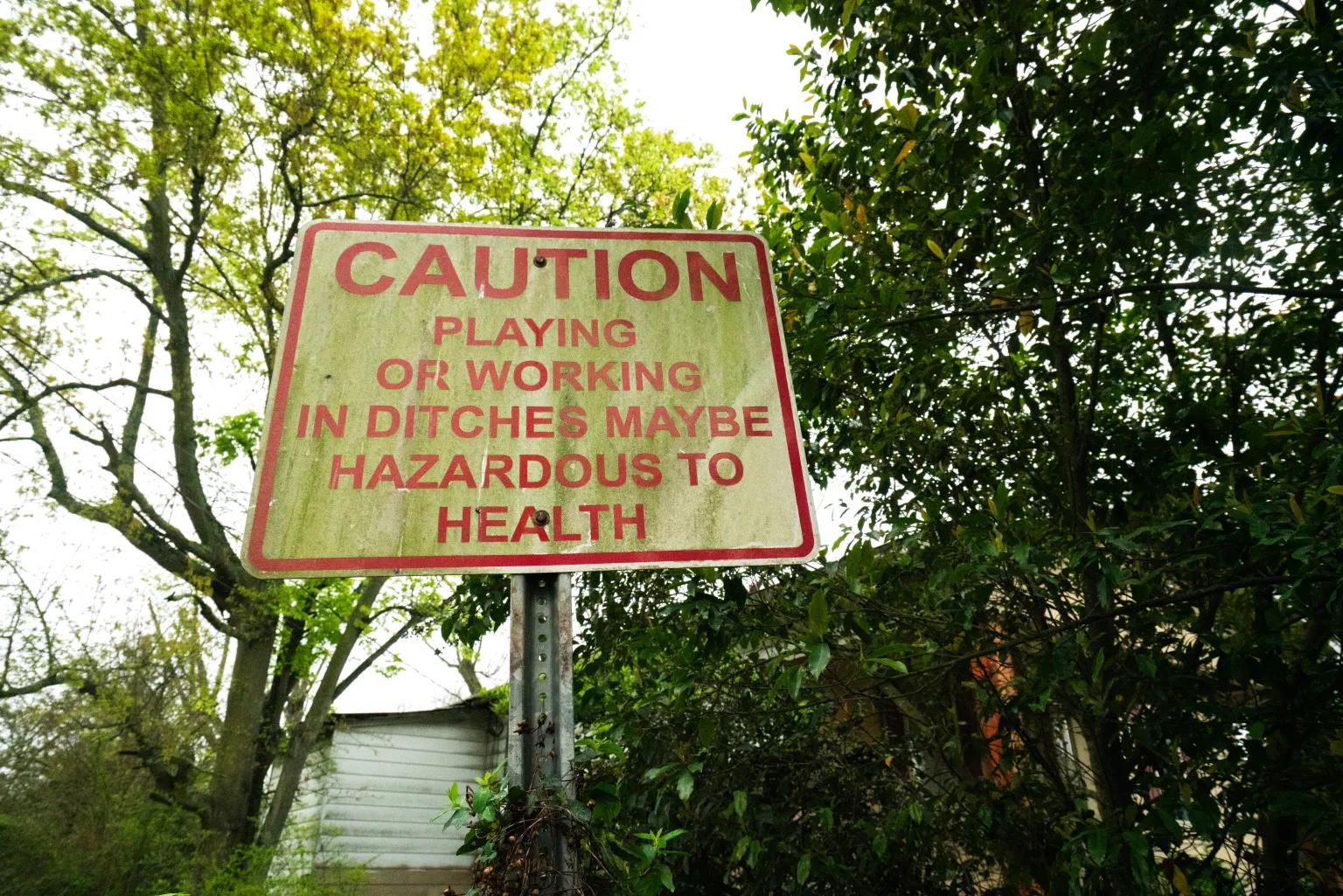 A sign that reads Caution playing or working in ditches may be hazardous to health