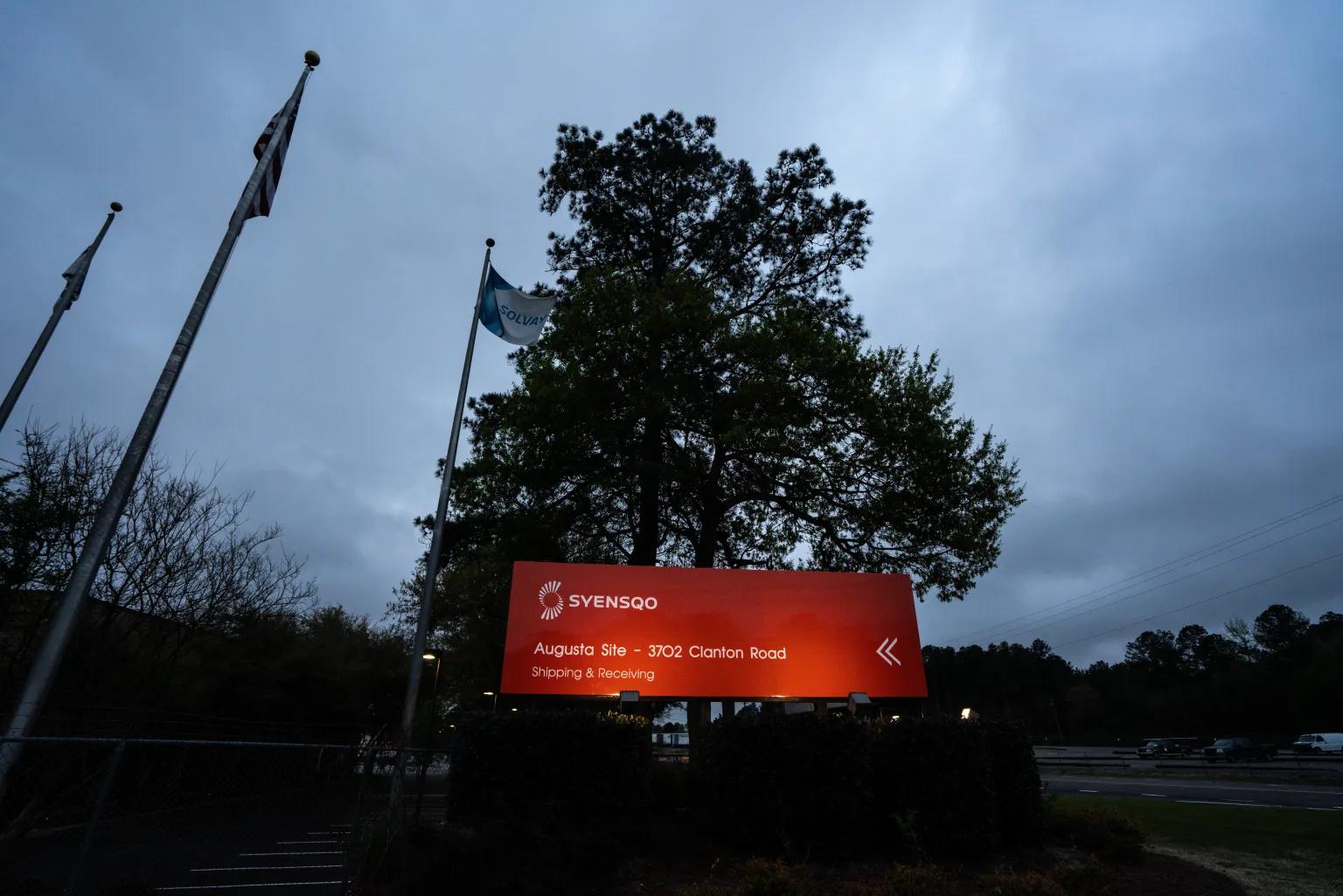 A red sign for Syensqo’s Augusta facility at night.