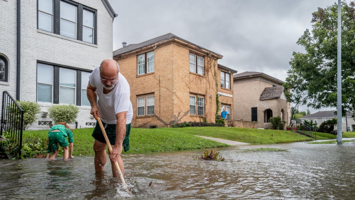 Jack Reyna and his son work to drain floodwater in their neighborhood of Houston, Texas, after Hurricane Beryl swept through the area on July 8, 2024.