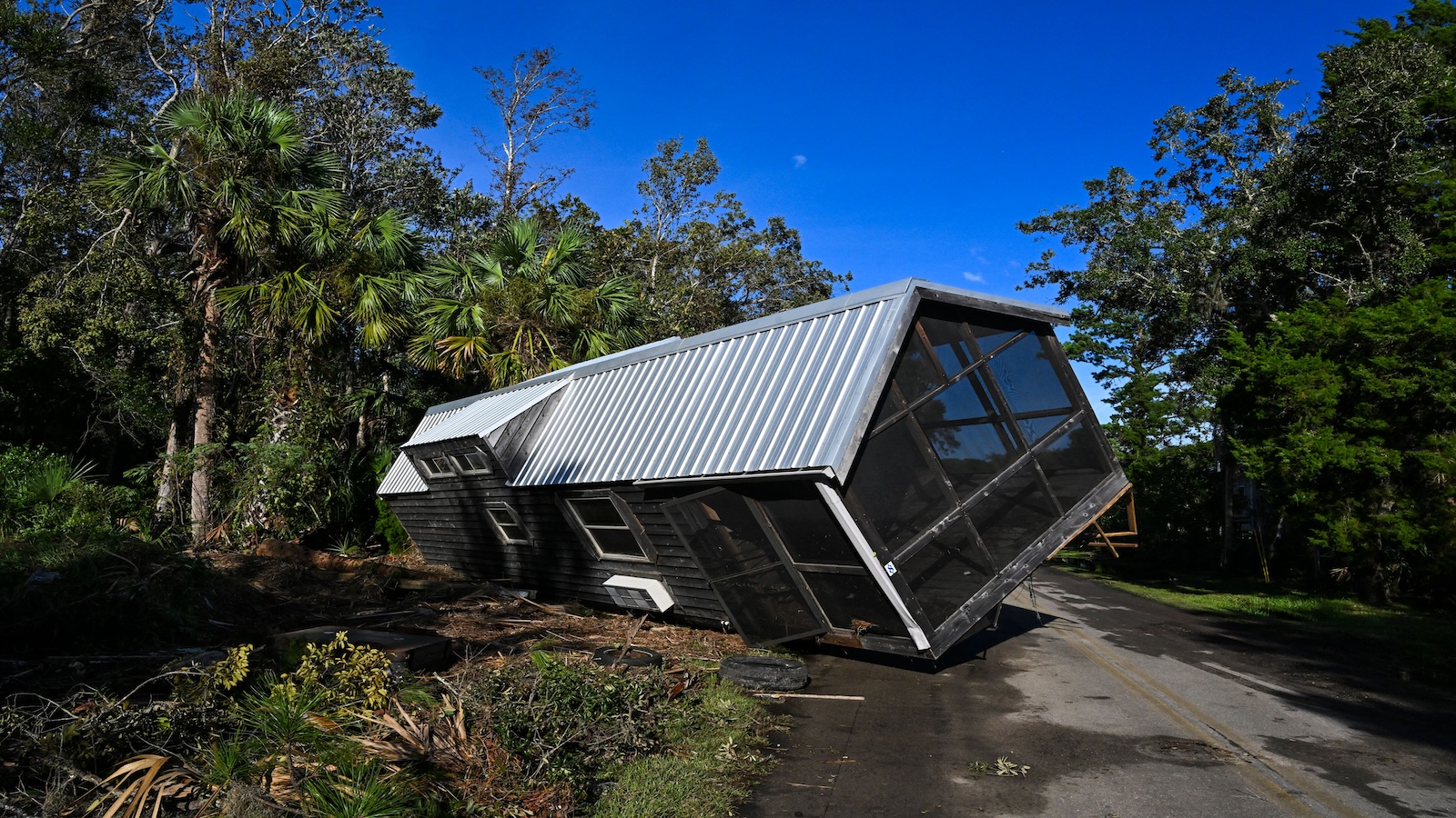 A mobile home lays flipped on its side after a hurricane
