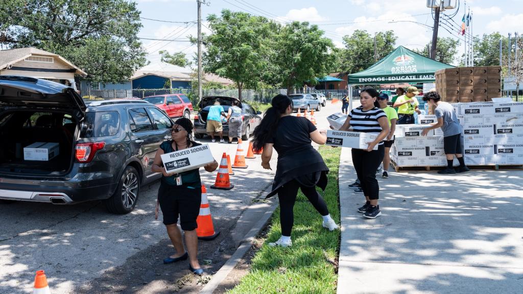 People receive free food at a distribution site after a hurricane.