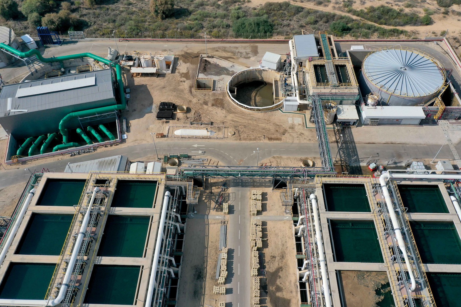 An aerial view of a desalination plant including pools of water and pipes