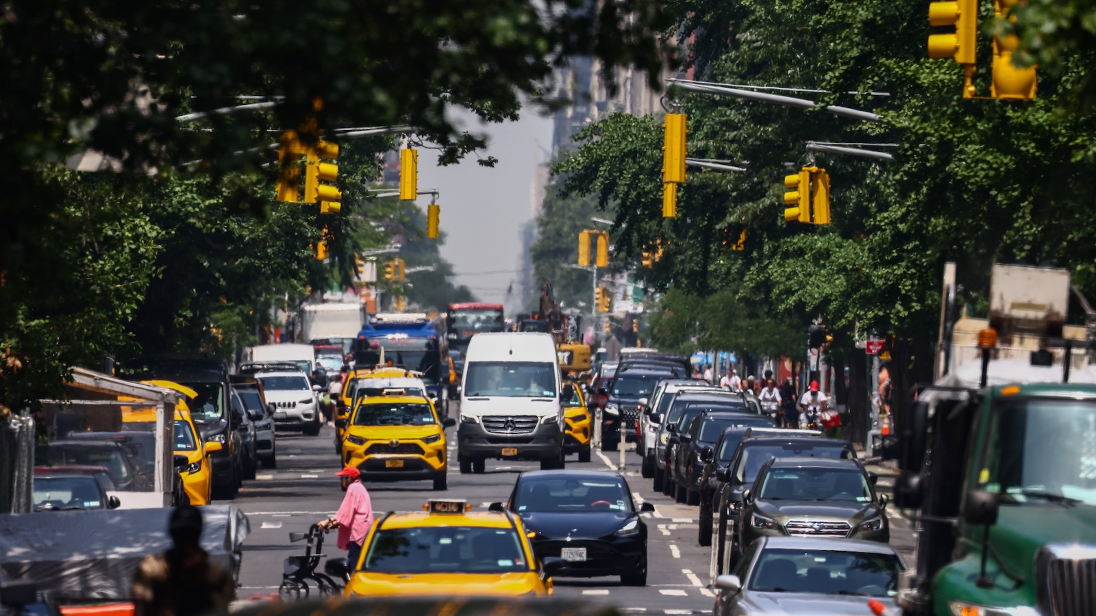 Heavy traffic and pedestrians are seen on Fifth Avenue in New York during a hazy day in July.
