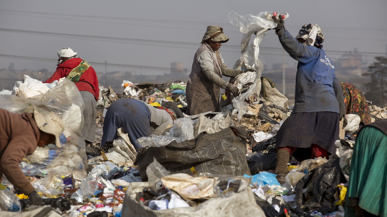 A group of waste pickers pick up trash from a dumpsite.