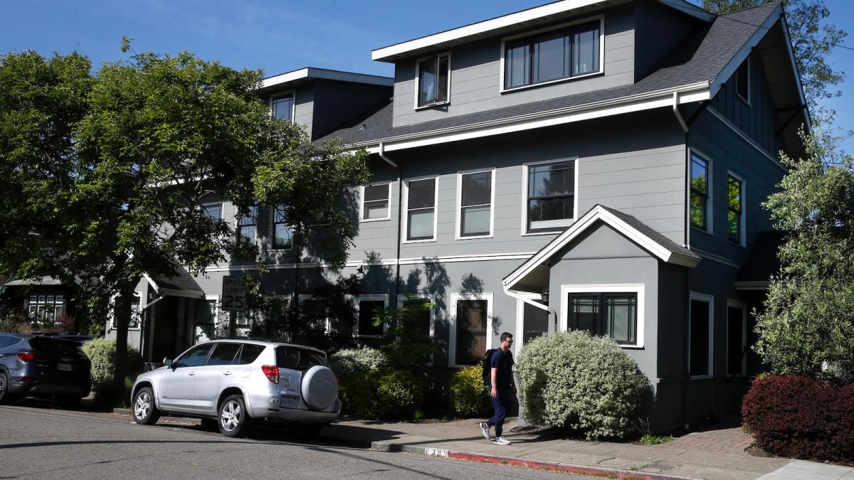 A man walks past a new fourplex, or four-unit, housing unit in Oakland, California.
