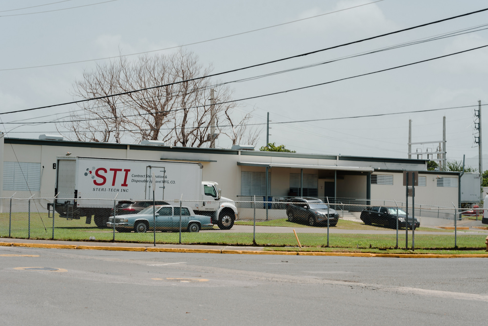 trucks line up oustide an industrial building marked STI