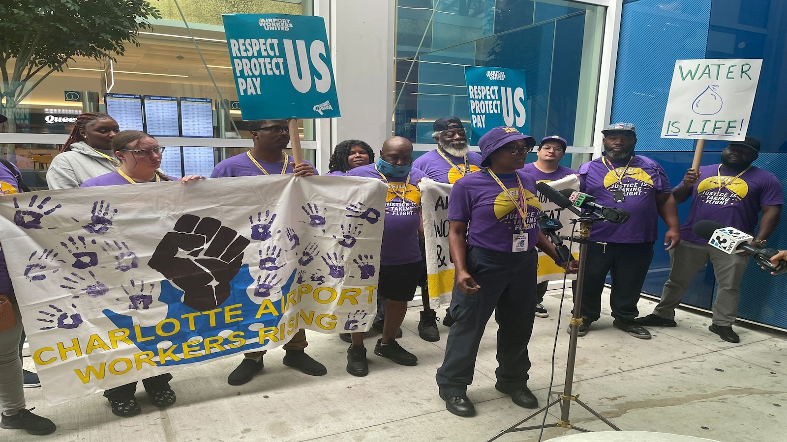 A group of people gather outside an airport