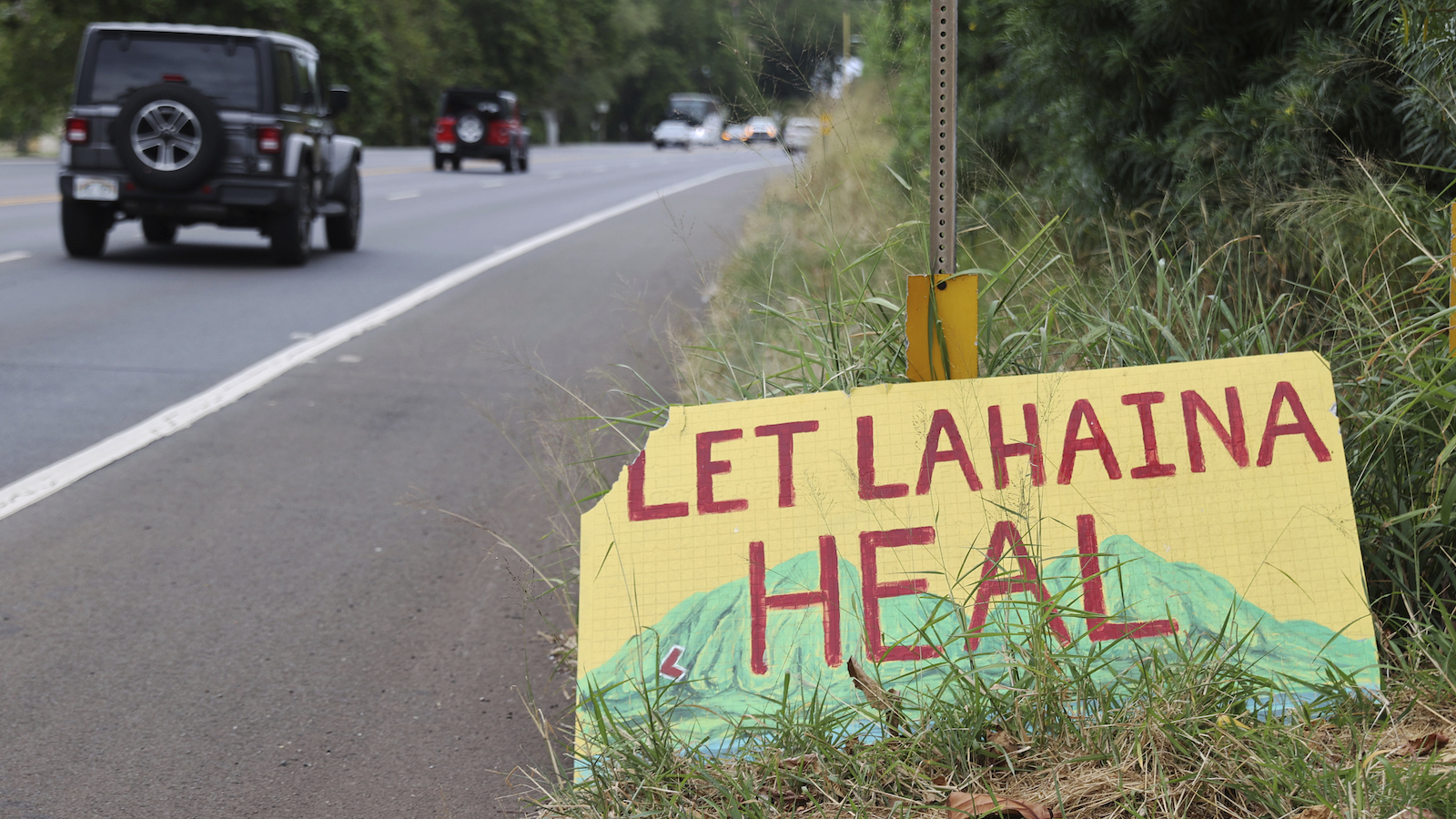 A handpainted sign in yellow, red and green reads 