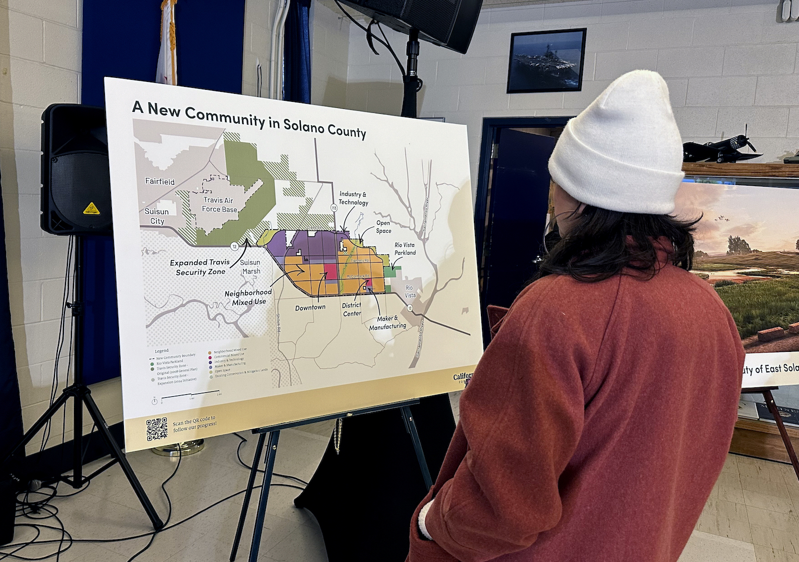 A person looks at a map poster that reads, 