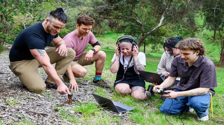 A group of people sit in the soil