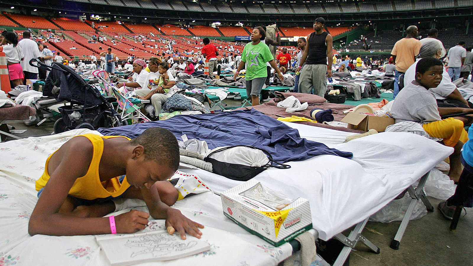 A Katrina evacuee spends time coloring a book in the Houston Astrodome on September 3, 2005