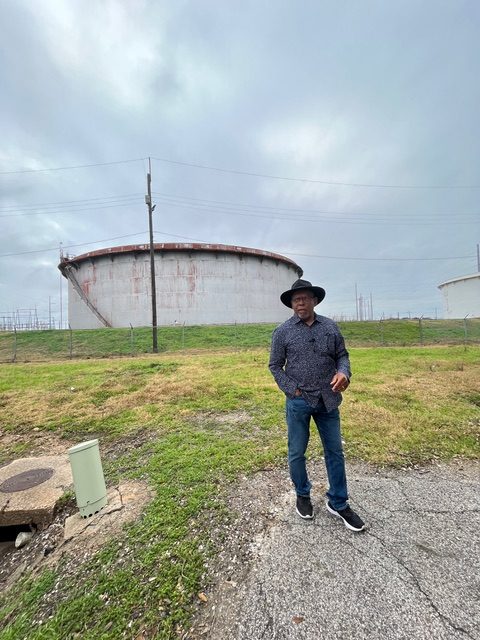 John Beard stands in front of refinery equipment in Port Arthur