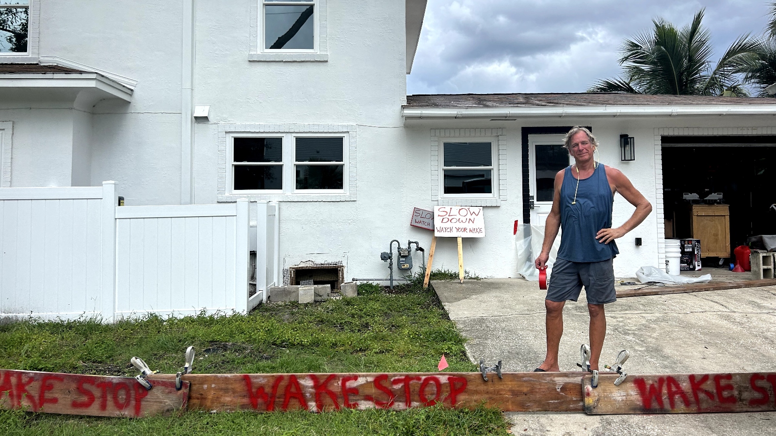 Homeowner stands near Wake Stop signs