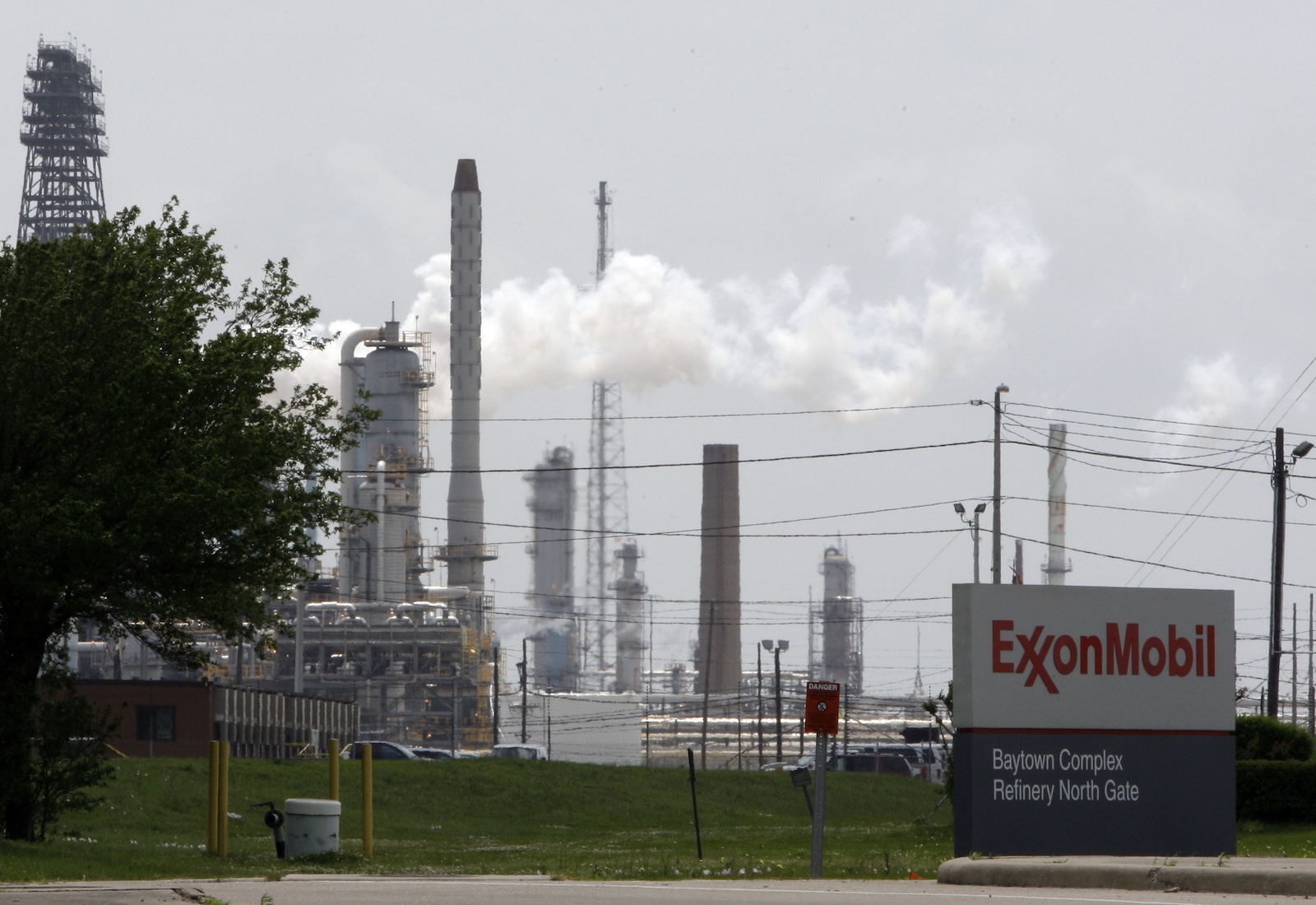 Smokestacks in background with sign in foreground reading ExxonMobil Baytown Complex Refinery North Gate