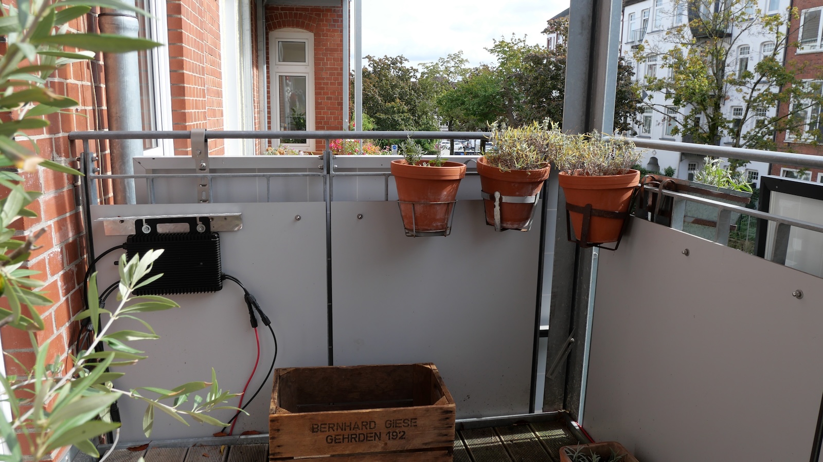 The back of a pair of solar panels is seen from the balcony of an apartment that uses the technology to provide power.